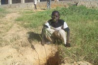 Planting a tree near the school - - this boy will look after the tree for the next 12 months